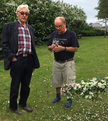 Stig i den lummiga trädgården på Soldattorpet. Här med Arne framför den scherrsminhäck som Stig hjälpt till att plantera.