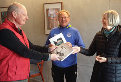 Museiföreningens Rolf Hansson överräcker boken med Limhamnsfoton till Barbro Borglundh. I mitten syns en annan av de lyckliga vinnarna Peter Anderberg.